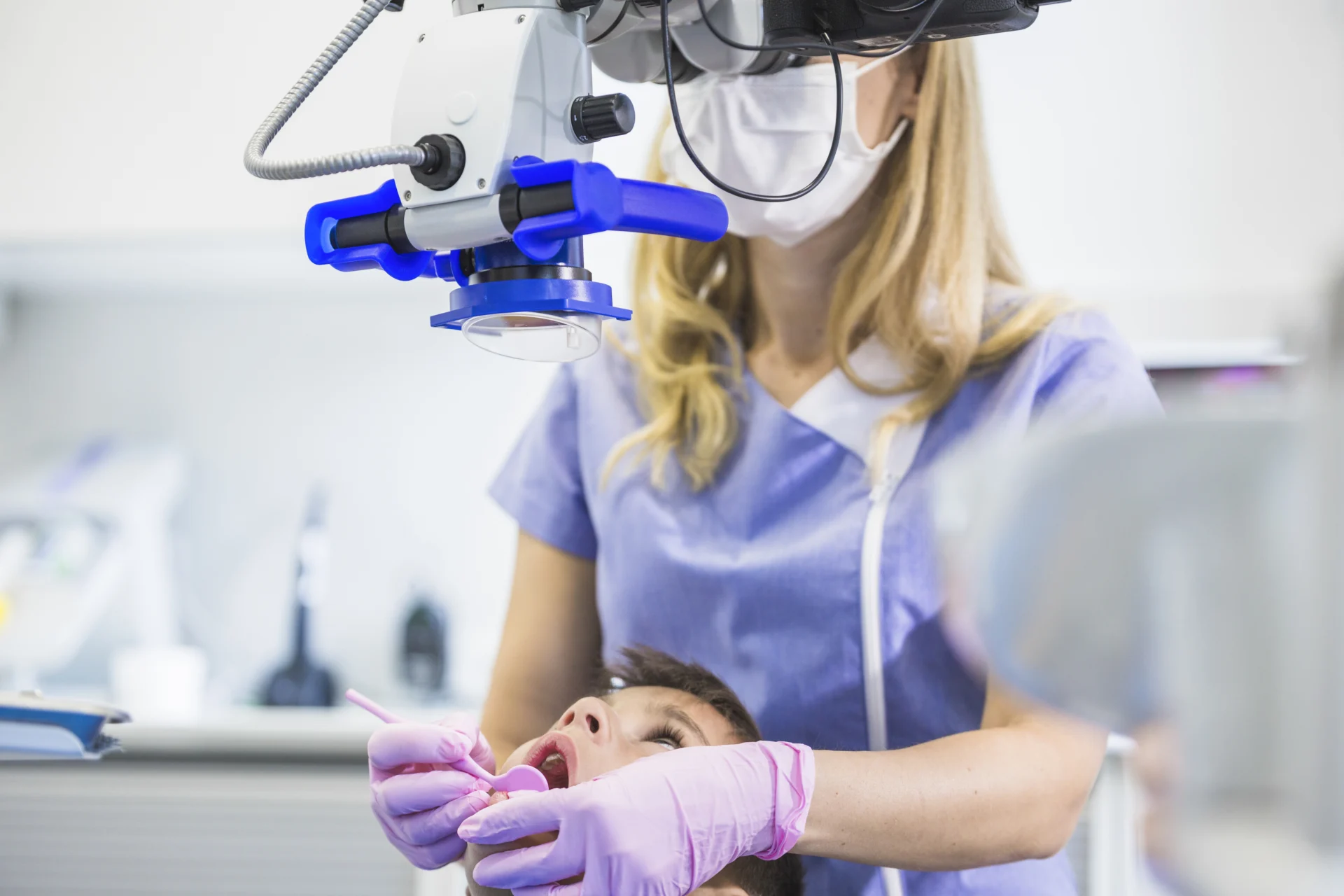 Dentist examining patient s teeth through microscope clinic