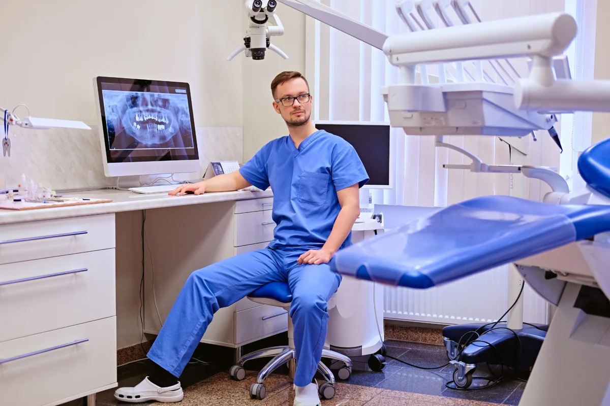 Male dentist looking teeth x ray computer dentist office