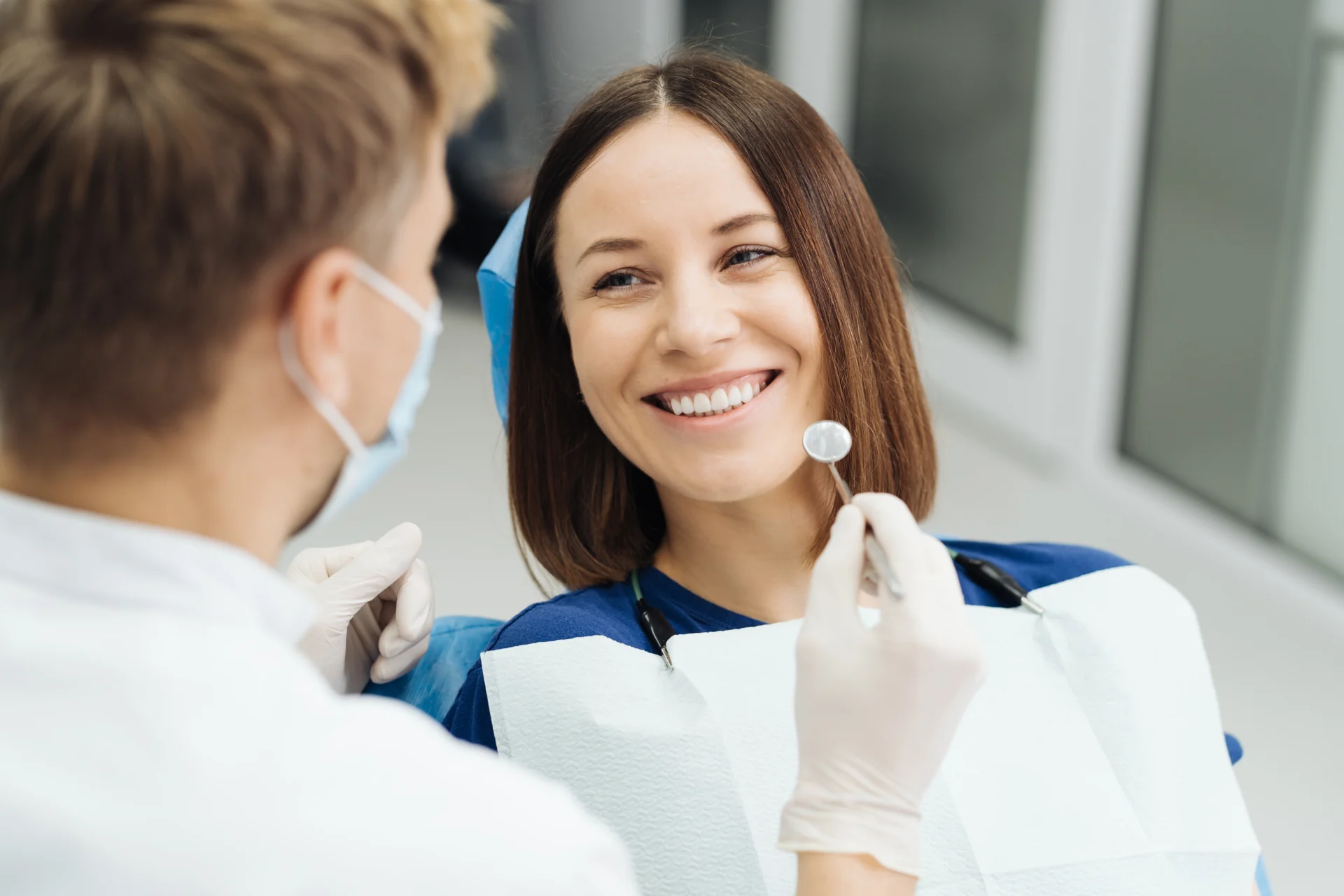 Male professional dentist with gloves mask discuss what treatment will look like patient s teeth